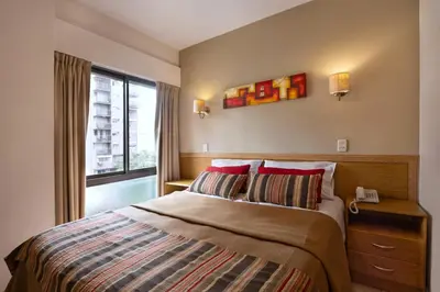 a bedroom with a bed with a window and a phone at Concord Rent Apart in Cordoba