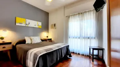a bedroom with a bed and a large window at Concord Rent Apart in Cordoba