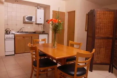 a kitchen with a wooden table with a vase of flowers on it at Concord Rent Apart in Cordoba