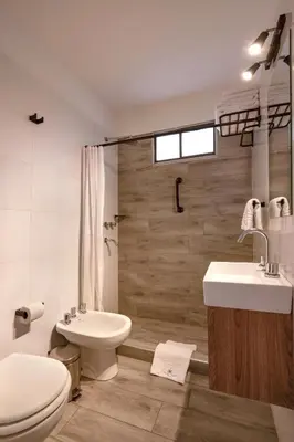 a white bathroom with a toilet and a sink at Concord Rent Apart in Cordoba