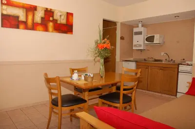 a kitchen and dining room with a wooden table and chairs at Concord Rent Apart in Cordoba