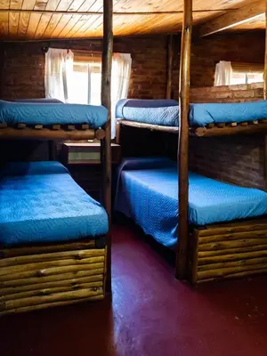 a room with four bunk beds in a cabin at Quebrada del Viento - Cabañas in Los Hornillos