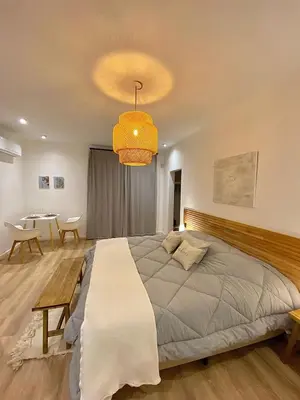 a bedroom with a large bed and a table at Magnolia Suites in Nono