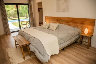 a bedroom with a large bed with a wooden headboard at Magnolia Suites in Nono