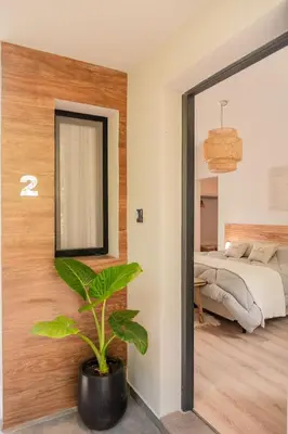 a bedroom with a mirror and a plant at Magnolia Suites in Nono