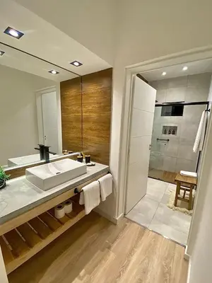 a bathroom with a sink and a large mirror at Magnolia Suites in Nono