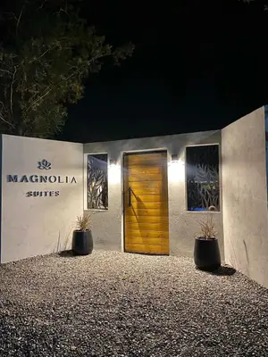 a door to a building with two plants in front at Magnolia Suites in Nono