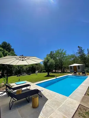 a swimming pool with a table and an umbrella at Magnolia Suites in Nono