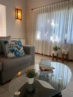 a living room with a couch and a glass table at Lirios del Campo - Chumamaya Merlo SL in Merlo