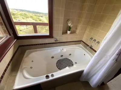 a bath tub in a bathroom with a window at Lirios del Campo - Chumamaya Merlo SL in Merlo