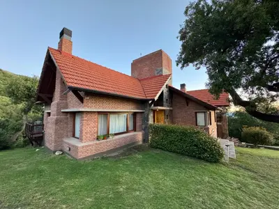 a brick house with a red roof on a yard at Lirios del Campo - Chumamaya Merlo SL in Merlo