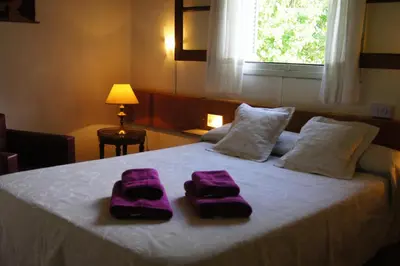 a bed with two purple towels on top of it at Lorelei in Mina Clavero