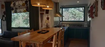 a kitchen with a wooden table and some windows at La Llilda in La Bolsa