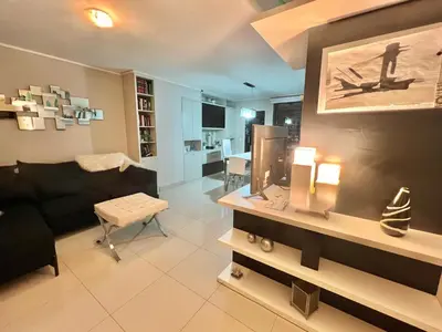 a living room with a black couch and a tv at Deluxe Nueva Córdoba - Premium Balcón & Asador in Cordoba
