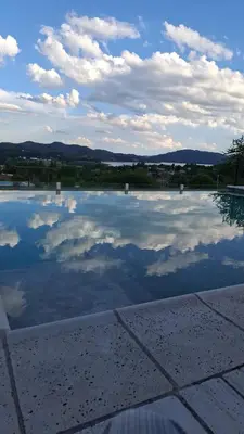 a pool of water with clouds in the sky at Aldea Mate Amargo in Potrero de Garay