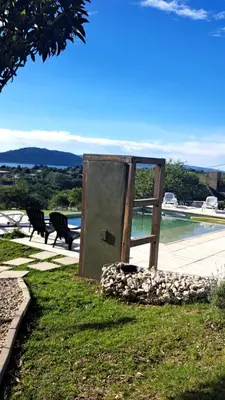 a wooden box sitting in the grass next to a pool at Aldea Mate Amargo in Potrero de Garay