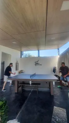 two men standing around a large ping pong table at Aldea Mate Amargo in Potrero de Garay