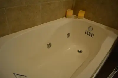 a white bath tub with two candles on top of it at Cabañas La Belen in Merlo