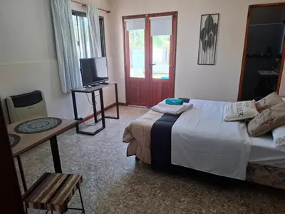 a bedroom with a bed and a television and a table at Loma del Alto in Alta Gracia