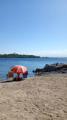 two chairs and an umbrella on a beach at Refugio Amaicha in Embalse