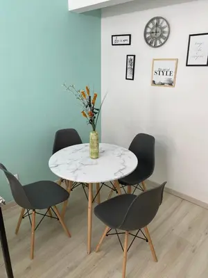 a table with four chairs and a vase with flowers at Departamento HOSPITAL PRIVADO - QUALITY - CORDOBA in Cordoba
