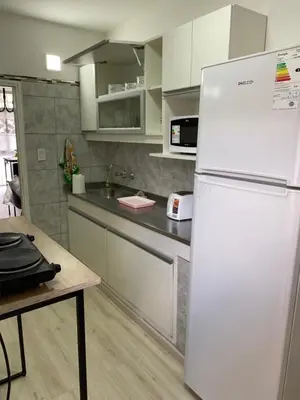 a kitchen with a white refrigerator and a table at Departamento HOSPITAL PRIVADO - QUALITY - CORDOBA in Cordoba