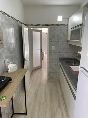a kitchen with a counter and a sink and a door at Departamento HOSPITAL PRIVADO - QUALITY - CORDOBA in Cordoba