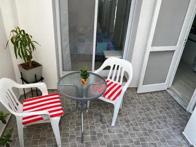 a glass table with two chairs and a potted plant at Departamento HOSPITAL PRIVADO - QUALITY - CORDOBA in Cordoba