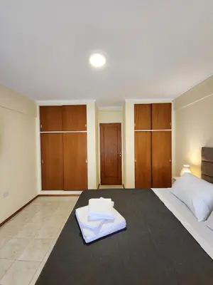 a large bedroom with a large bed with wooden cabinets at Obispo Oro 451 - Nueva Córdoba in Cordoba