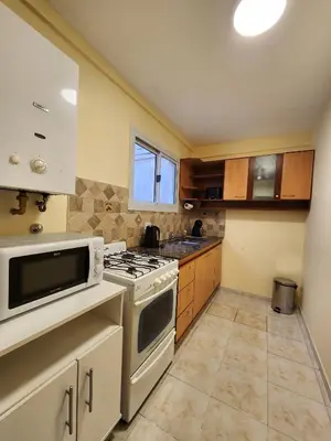 a kitchen with a stove and a microwave at Obispo Oro 451 - Nueva Córdoba in Cordoba