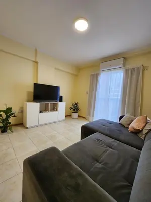 a living room with a couch and a flat screen tv at Obispo Oro 451 - Nueva Córdoba in Cordoba