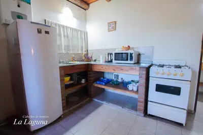 a kitchen with a white refrigerator and a microwave at La Laguna - Cabañas de Troncos in Merlo