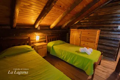 a bedroom with two beds in a log cabin at La Laguna - Cabañas de Troncos in Merlo