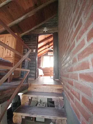 an attic room with stairs and a brick wall at La Laguna - Cabañas de Troncos in Merlo