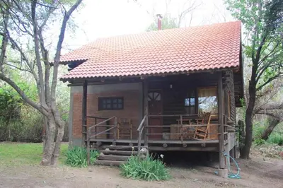 a small house with a red roof and a porch at La Laguna - Cabañas de Troncos in Merlo