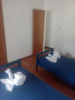two beds in a room with towels at Casa 3 Habitaciones, 2 baños pileta a compartir con el anfitrion - in Cordoba