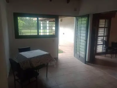 a table and chairs in a room with a table and a door at Casa 3 Habitaciones, 2 baños pileta a compartir con el anfitrion - in Cordoba