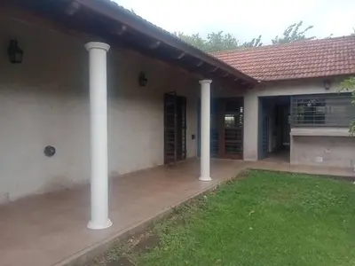 a house with white columns in a yard at Casa 3 Habitaciones, 2 baños pileta a compartir con el anfitrion - in Cordoba