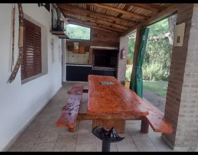 a large wooden table on a patio in a house at Casa Del Arroyo in Arroyo de Los Patos