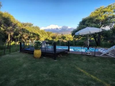 a pool with a table and an umbrella next to at Casa Del Arroyo in Arroyo de Los Patos