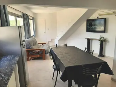 a dining room with a black table and chairs at Complejo Costa Linda in Villa Carlos Paz