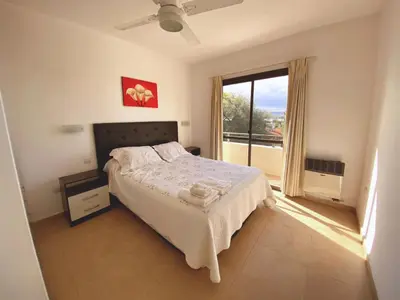 a bedroom with a bed and a large window at Complejo Costa Linda in Villa Carlos Paz