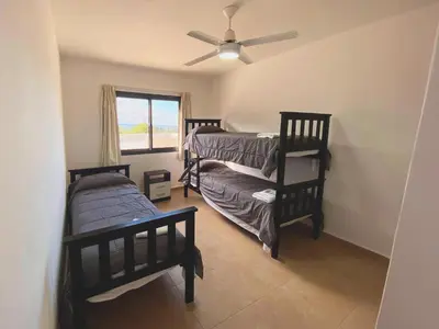 a bedroom with two bunk beds and a ceiling fan at Complejo Costa Linda in Villa Carlos Paz