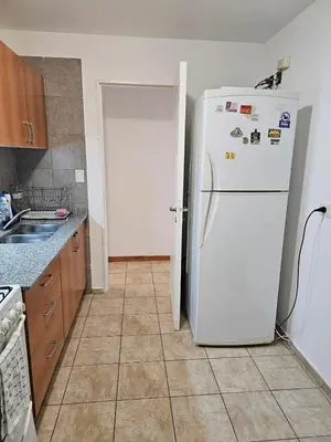 a kitchen with a white refrigerator and a tile floor at Amplio Depto en Pleno Centro! in Cordoba