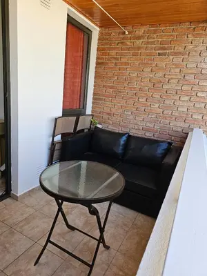 a living room with a black couch and a glass table at Amplio Depto en Pleno Centro! in Cordoba