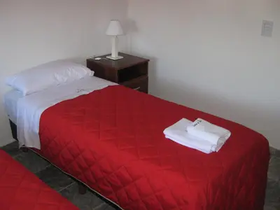 a hotel room with a red bed with a red blanket at Cabañas Luna del Sur in Merlo