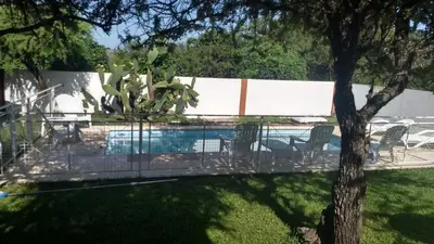a fence with chairs and a pool in a yard at Cabañas Luna del Sur in Merlo