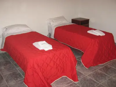 two beds with red covers in a room at Cabañas Luna del Sur in Merlo