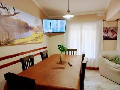 a living room with a table and a television on the wall at Casa Arenales in Almafuerte