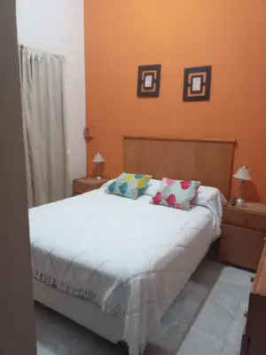 a bedroom with a bed with white sheets and pillows at Casa Arenales in Almafuerte